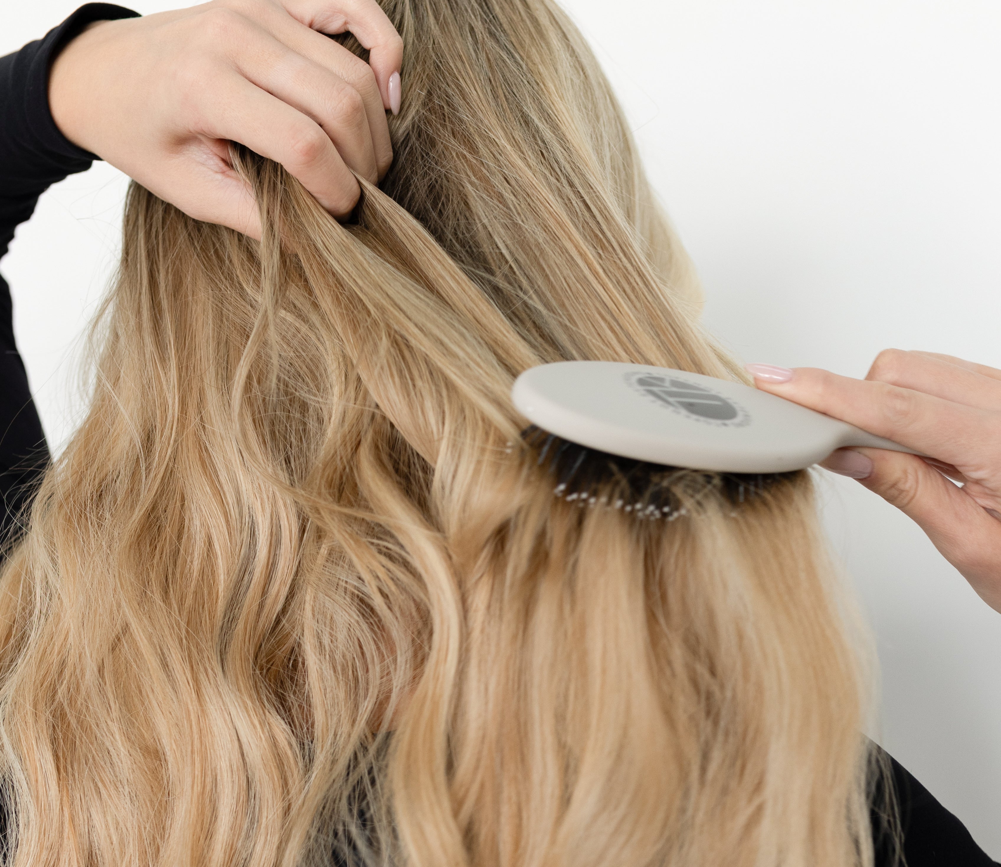 Brushing Top Knot hair extensions with an extension-safe brush